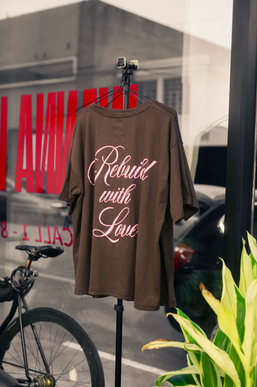 Playera Rebuild with Love expuesta en el ventanal de Studio 99
