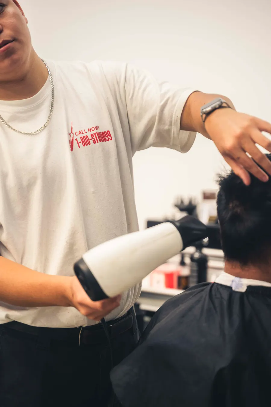 Barbero de Studio 99 secando el cabello a un cliente